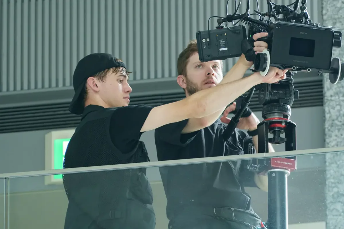 Grant Hall adjusting a cinema camera with a crew member