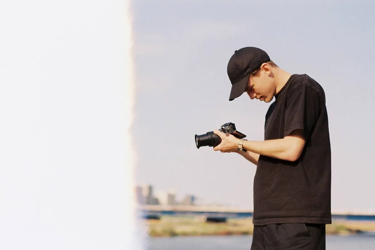 Grant Hall checking camera settings while filming outdoors